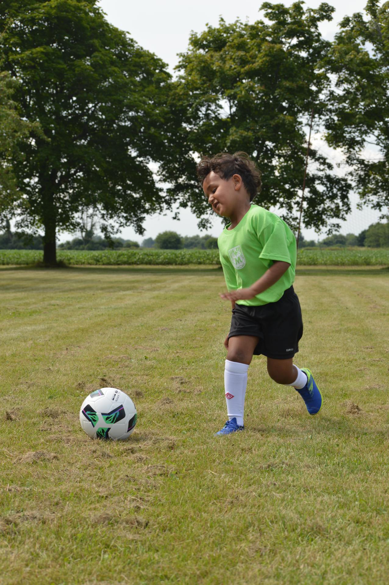 Young Maravilha Mini's player running to kick a soccer ball